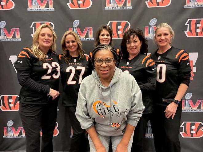 Karen Roseman-Harris poses with a group of American Airlines flight attendants in front of a Super Bowl 56 backdrop. Roseman-Harris has organized about 100 road trips to Bengals away games during the past 35 years.