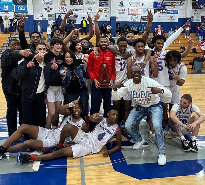The Pine Forest boys basketball team celebrates after winning the District 1-5A title by defeating Choctaw 70-62 on Feb. 11, 2022 from Arnold High School.