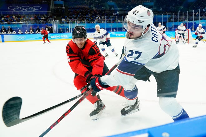 Forward Noah Cates (27) helped Team USA defeat Canada and forward Adam Tambellini (15) in a preliminary round game at the 2022 Beijing Olympics.
