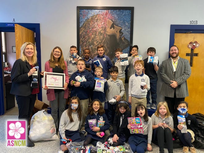 Denise Lawson and her third-grade students at St. Anna Catholic School pose for a photo with Aging Services of North Central Massachusetts CEO Lori Richardson and Chief Marketing Officer David Ginisi.