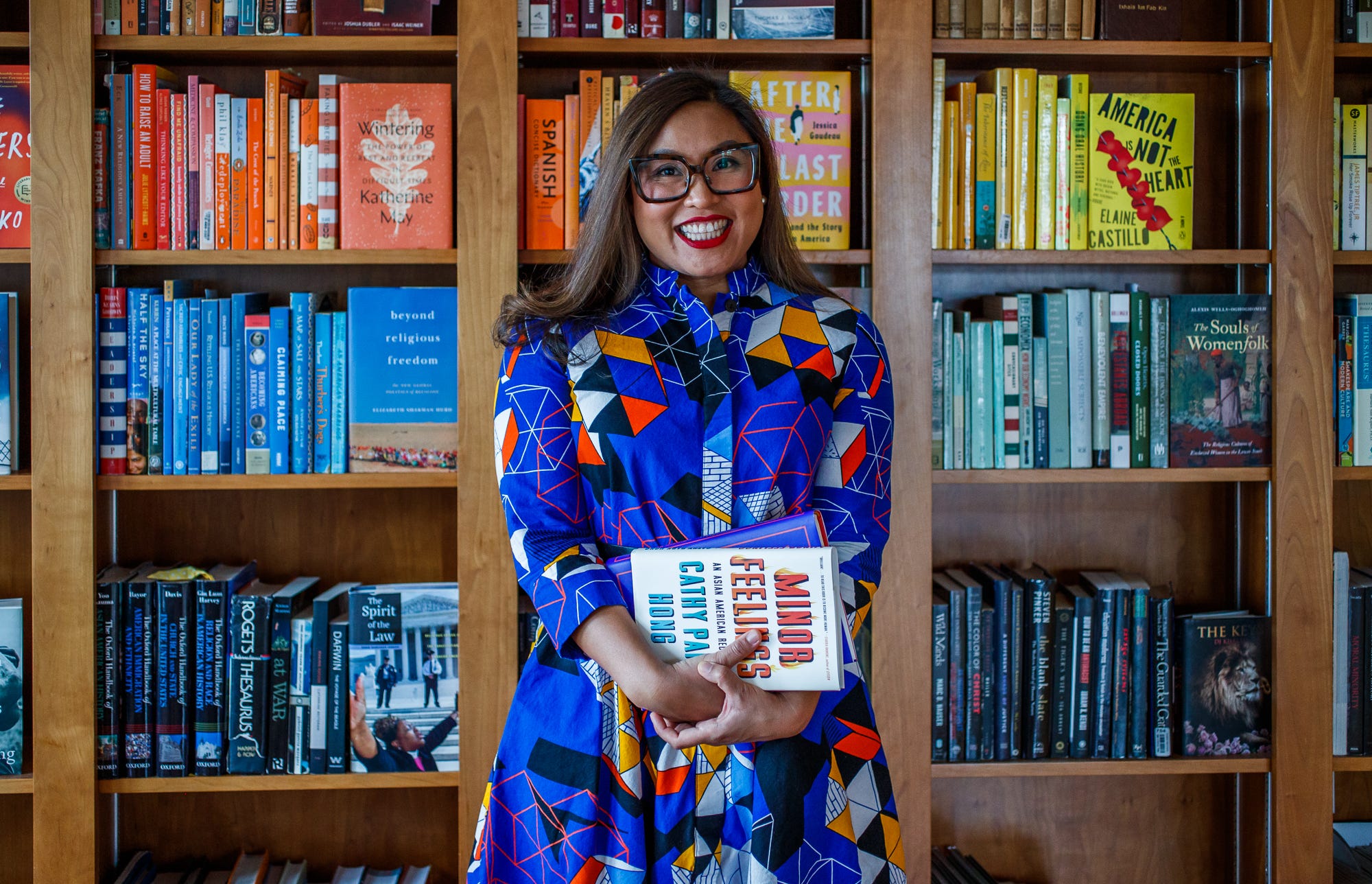 Dr. Melissa Borja stands in front of a wall of books Friday, Feb. 11, 2022, inside her home in Indianapolis. Borja is being recognized for her role as an educator and her work documenting anti-Asian hate incidents during the pandemic.