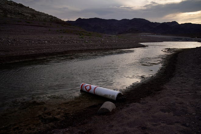 A buoy once used to warn of a submerged rock rests on the ground along the waterline near a closed boat ramp on Lake Mead at the Lake Mead National Recreation Area on Aug. 13, 2021, near Boulder City, Nev.
