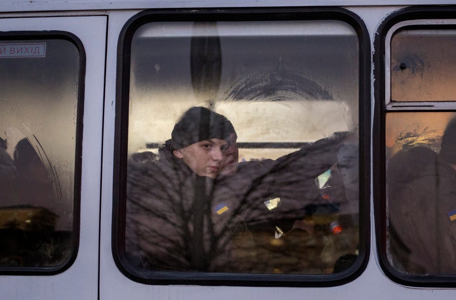 Members of National Guard of Ukraine look out of the window as they ride in a bus through the city of Kyiv on Feb. 14, 2022. More NATO troops headed to Eastern Europe and some nations worked to move their citizens and diplomats out of Ukraine on Monday, as Germany's chancellor made a last-ditch attempt to head off a feared Russian invasion that some warn could be just days away.
