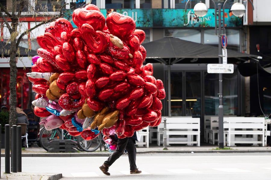 St. Valentine might have been beheaded over a thousand years ago, but these days, we celebrate Valentine's Day in more conventional ways. A man walks on Valentine's Day with a bunch of red heart balloons through the city of Frankfurt, Germany.