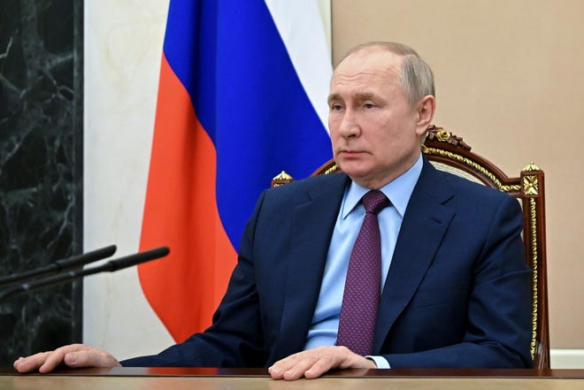 Russian President Vladimir Putin listens to Russian Russian Defense Minister Sergei Shoigu during their meeting in Moscow on Feb. 14.