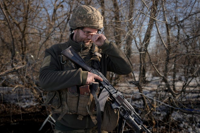 A Ukrainian serviceman adjusts his glasses at a frontline position, outside Popasna, Luhansk region, eastern Ukraine, on Feb. 14, 2022.