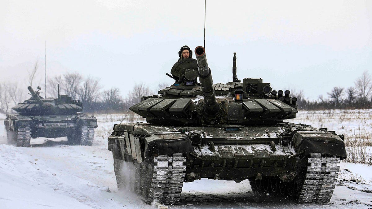 In this photo provided by the Russian Defense Ministry Press Service on Monday, Feb. 14, 2022, Russian tanks roll on the field during a military drills in Leningrad region, Russia.
