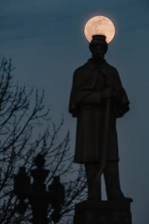 The 2022 Snow Moon rises behind a statue of Major Henry Kaldenbaugh, who  served in the 51st infantry division in the Civil War, and left a bequest in his will for the construction of the monument to honor GAR (Union) soldiers, Tuesday, Feb. 15 in front of the Tuscarawas County Courthouse in downtown New Philadelphia.