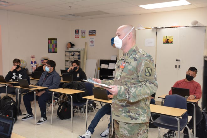 Captain Zack Jones, a lawyer in the Army's Judge Advocate office and an attorney in the office of the State Attorney General's Office,  takes attendance in a senior Government class before starting a lesson on New Mexico legislative action at Santa Teresa High School.