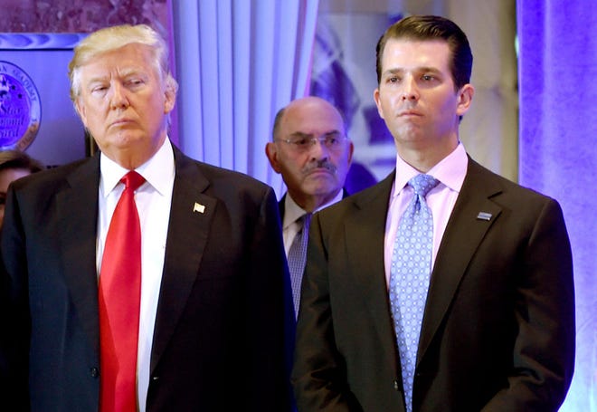 US President-elect Donald Trump along with his son Donald, Jr., arrive for a press conference at Trump Tower in New York, as Allen Weisselberg (center), chief financial officer of The Trump, looks on January 11, 2017. (TIMOTHY A. CLARY/AFP via Getty Images/TNS)