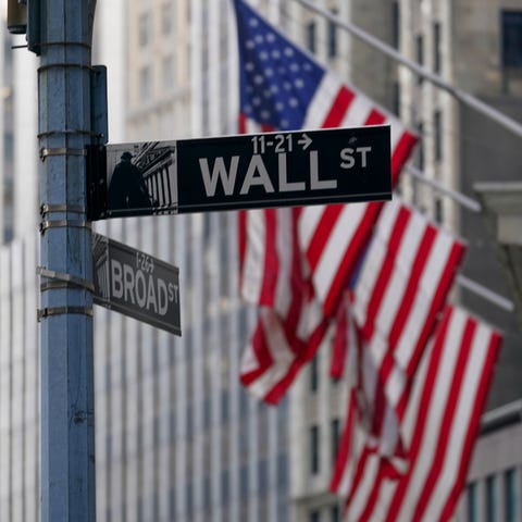 The Wall St. street sign is framed by the American