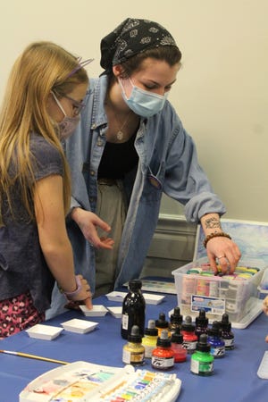 Nora Sheets, 9, of Monroe and Olivia Barton, a circulation clerk at Frenchtown-Dixie Branch Library, select which paints to use during the Frenchtown-Dixie Branch Library’s mindfulness painting class. Provided by Kennedy Bowling
