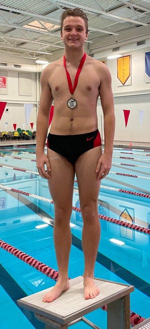 Pekin junior Cade Perfetti shows off the medal he received for finishing in first place in diving at the Mid-Illini Invitational at Pekin.
