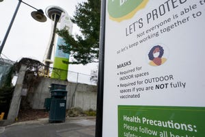 A sign near the Space Needle notes that masks are required for indoor spaces, Thursday, Feb. 17, 2022, in Seattle.