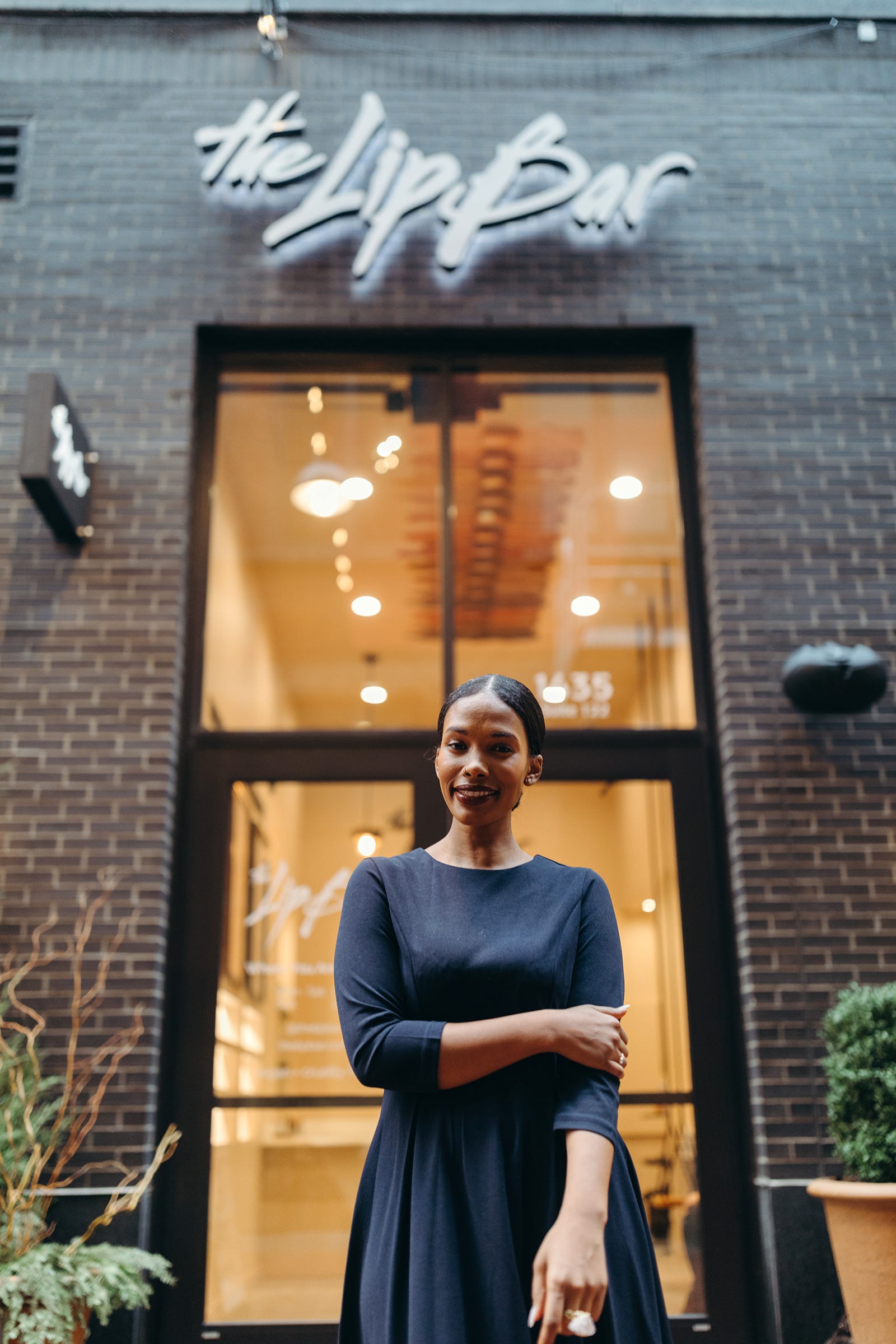 Melissa Butler, founder of The Lip Bar, stands in front of the company's flagship store, which is located at Parker's Alley in Detroit at 1435 Farmer St.