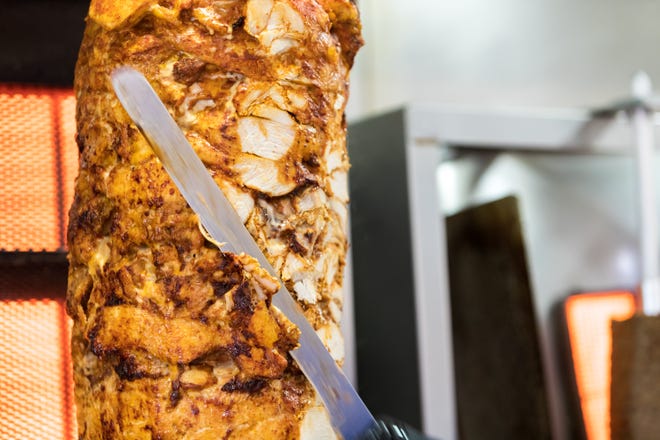 17 Şubat 2022'de Chandler'daki Supreme Shawarma'da mutfakta dikey bir şişten tavuk kesilir.