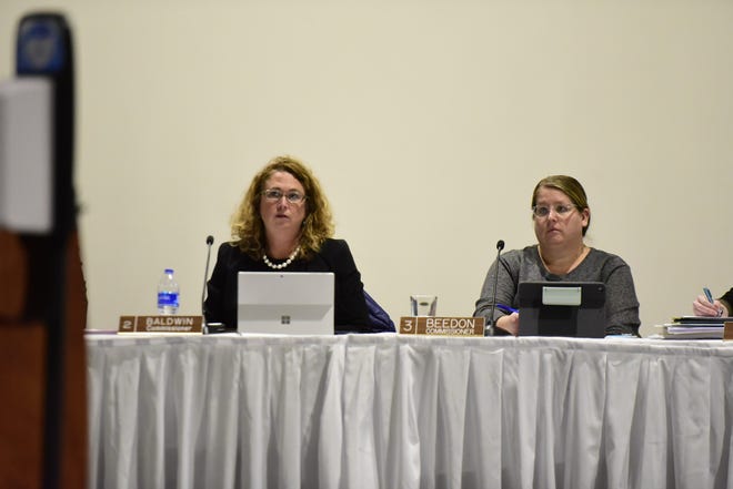 St. Clair County Commissioners Jorja Bladwin (left) and Lisa Beedon listen as public comments are made on the future of  Dr. Annette Mercatante's position during the St. Clair County Board of Commissioners meeting at the Blue Water Convention Center in Port Huron on Thursday, Feb. 17, 2022.