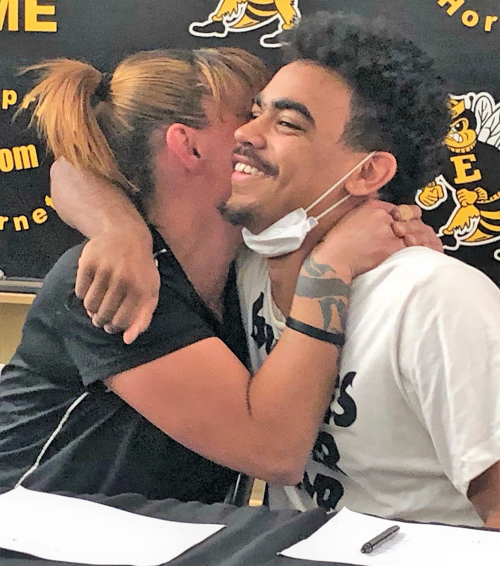 Enterprise High School football player O'Sirus Peoples gets a hug from his mother, Melissa Henry, after he signed his letter of intent on Feb. 3, 2022, to play football at Southern Oregon University in Ashland, Oregon, in the school's library.