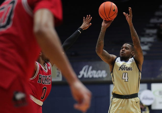 Akron Zips guard Bryan Trimble Jr. (4) attempts a shot for three during the first half of an NCAA basketball game against the Northern Illinois Huskies on Thursday.