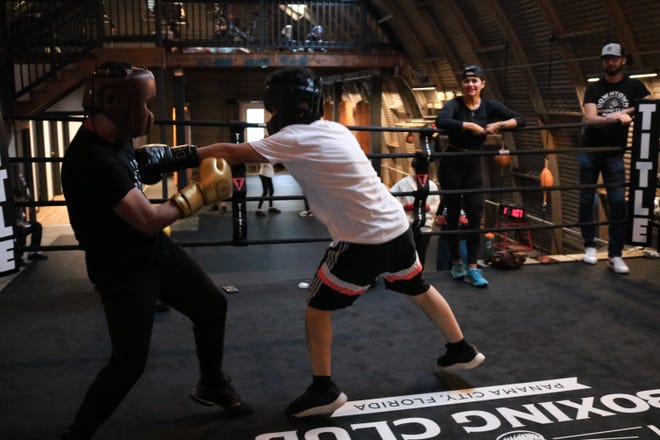 El entrenador de boxeo Felix Malespin entrena con uno de sus compañeros de clase en el ring de boxeo.