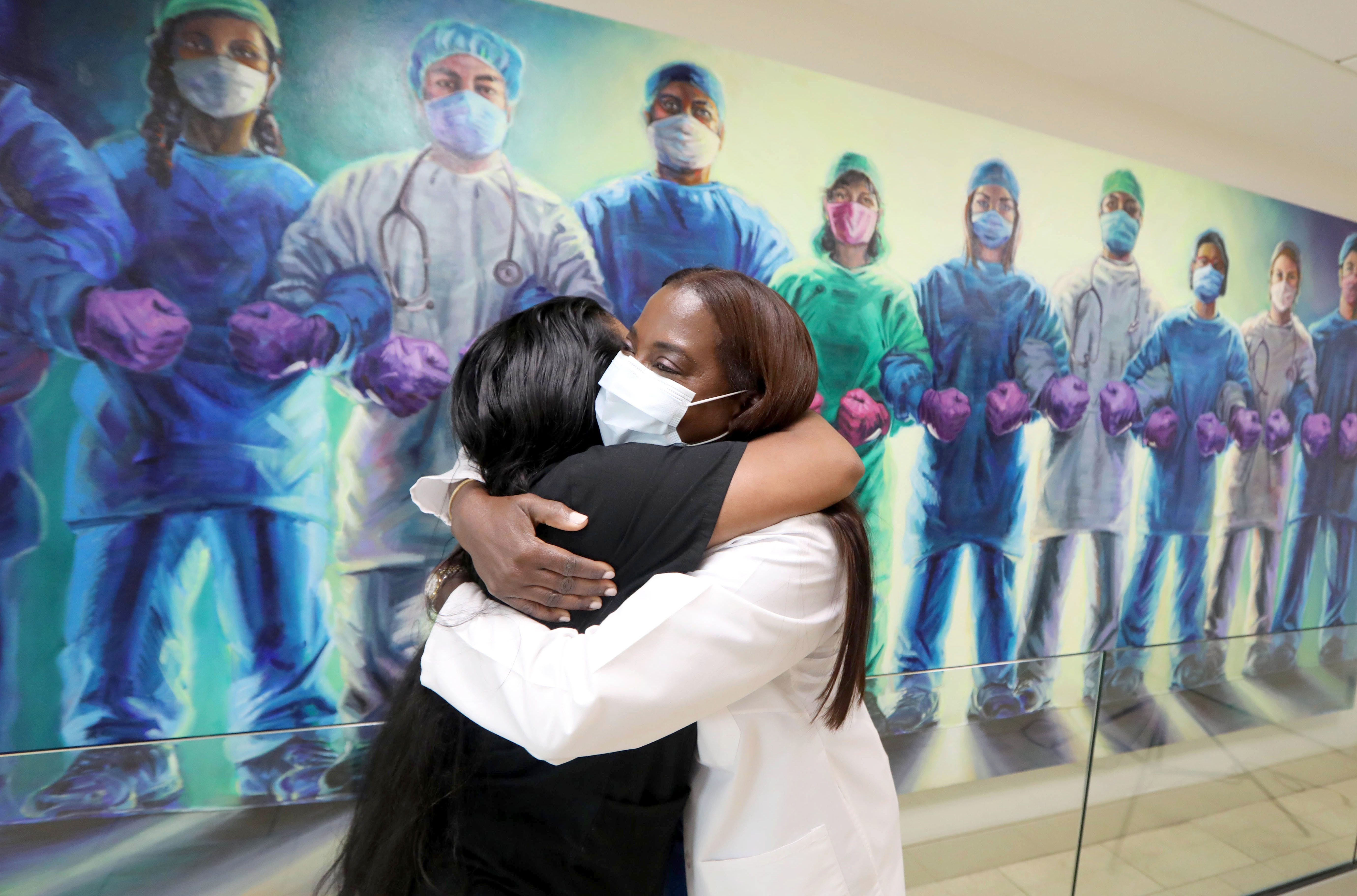 Sandra Lindsay, right, a nurse and the director of nursing for critical care at Long Island Jewish Medical Center in Queens, New York, hugs fellow nurse Patricia Rodriguez Feb. 18, 2022. Lindsay was the first person in the United States to receive an authorized COVID-19 vaccine when she received it on Dec. 14, 2020.