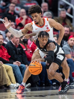 Louisville's El Ellis is guarded closely by Clemson's David Collins during first half action at the YUM Center. Feb. 19, 2022
