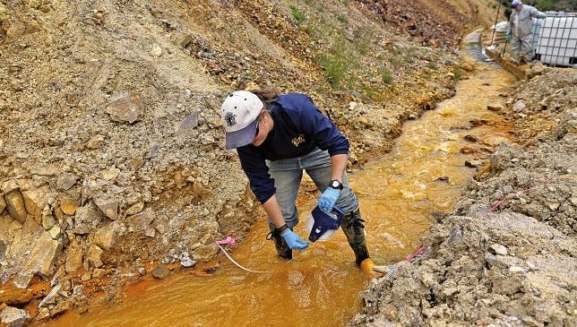 Megan Oller, an assistant engineer associate with Western Solutions Inc., measures water flowing out of Gold King Mine on Aug. 10, 2015.