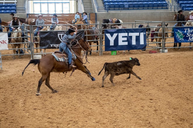 With lasso in air a rider bares down on a calf to rope  at the Three Star Memorial Roping  competition Sunday at the Tr-State Fairgrounds in Amarillo.