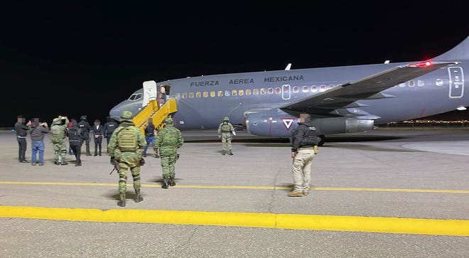 Jose Bryan Salgueiro Zepeda, who is suspected of being a leader in "Los Salgueiro" crime family, is escorted off a Mexican air force plane after landing in Chihuahua City following his arrest Friday during a baptism in a church in Culiacan, Sinaloa.
