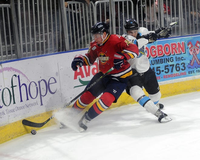 Peoria Rivermen defenseman/winger Austin Wisely digs for the puck in the corner and later scores his first pro goal in a 5-1 win over Quad City at Carver Arena on Sunday, Feb. 20, 2022.