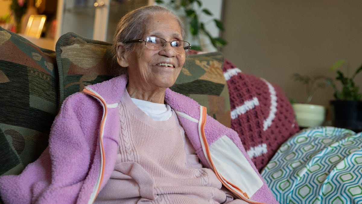 Evangelista DeJesus, who is almost 107, sits in her living room with her family in their home in Newburgh, NY, on Saturday, Feb. 20, 2022.