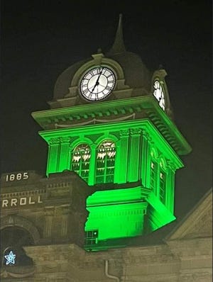 The Carroll County Courthouse is illuminated with green lights in memory of a traffic crash that killed a Conotton Valley High School senior and critically injured another.
