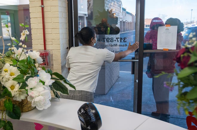 Cherelle Young, director of Bright Beginnings, a day care center a couple doors down from Chuck E. Cheese, Monday, Feb.  21, 2022, lets a customer and her child in a day after a man was fatally shot in the parking lot of the restaurant near Mitthoeffer Road and Washington Street.  
