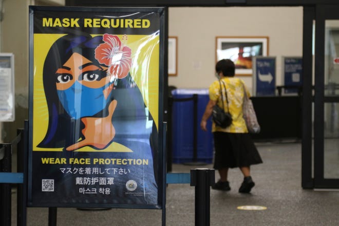 Signage in the Honolulu International Airport enforces Hawaii's indoor mask mandate in this Oct. 2, 2020, file photo.