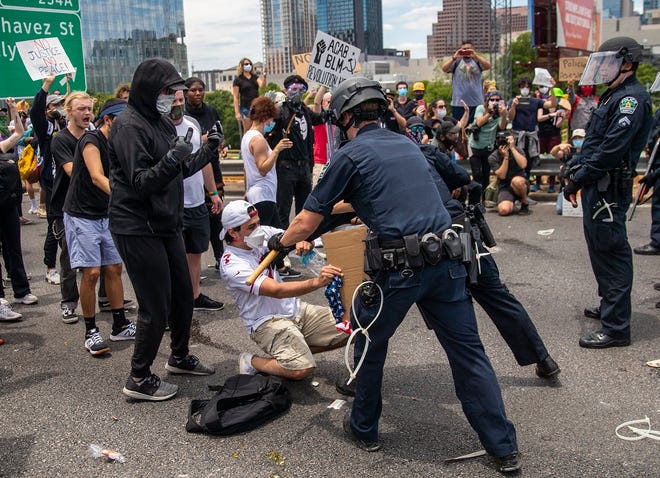 Austin police officers scuffle with a protester during demonstrations in May 2020. The city has now paid plaintiffs $13.95 million to a total of five people injured by police during the protests.