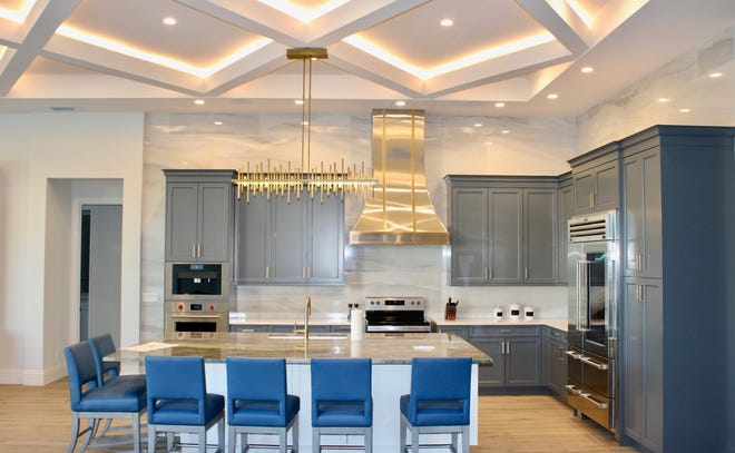 The home renovation, conducted by Gulfshore Homes, included enlarging the kitchen’s old island so seating could be added, updating the flooring and hood, and adding dramatic lighting to the ceiling.