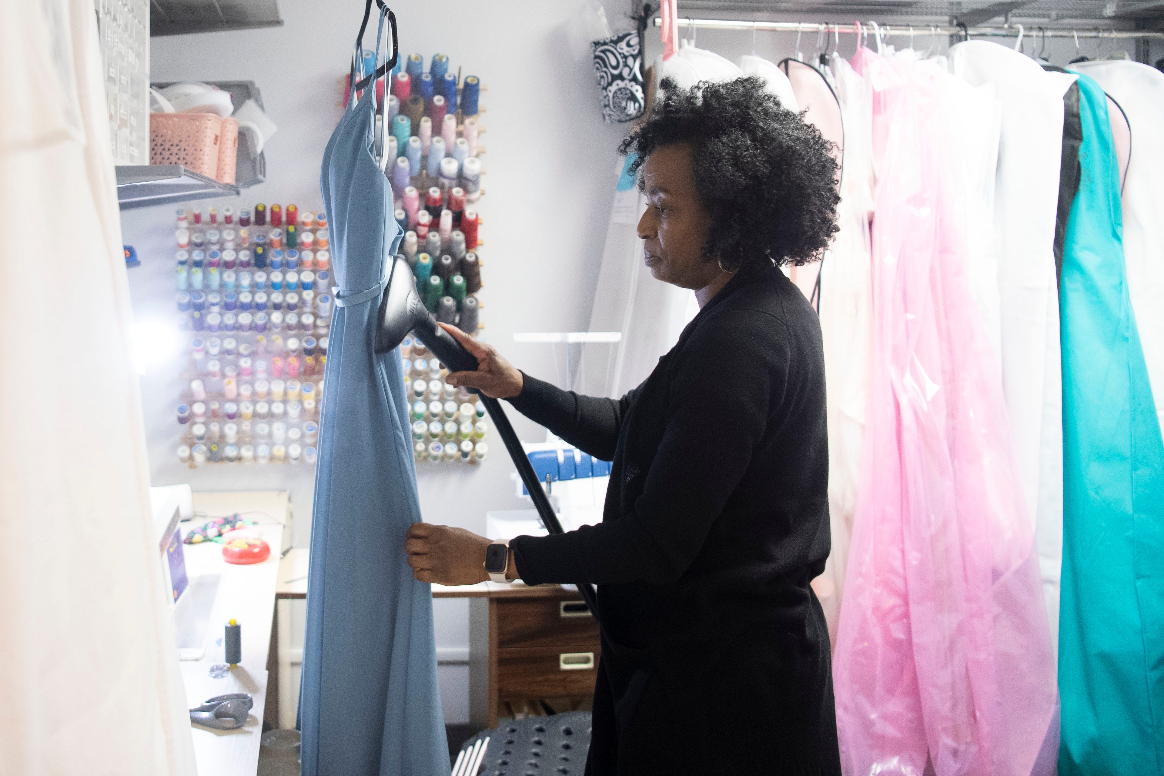 Kamesha Bowen-Jenkins steams a dress for a customer at her business Hem It Up. She opened her brick-and-mortar store on Ray Mears Boulevard at the height of the pandemic. Despite canceled weddings, brides still came to her for those just-right alterations. They got married in backyards or just wanted that special wedding dress photo.