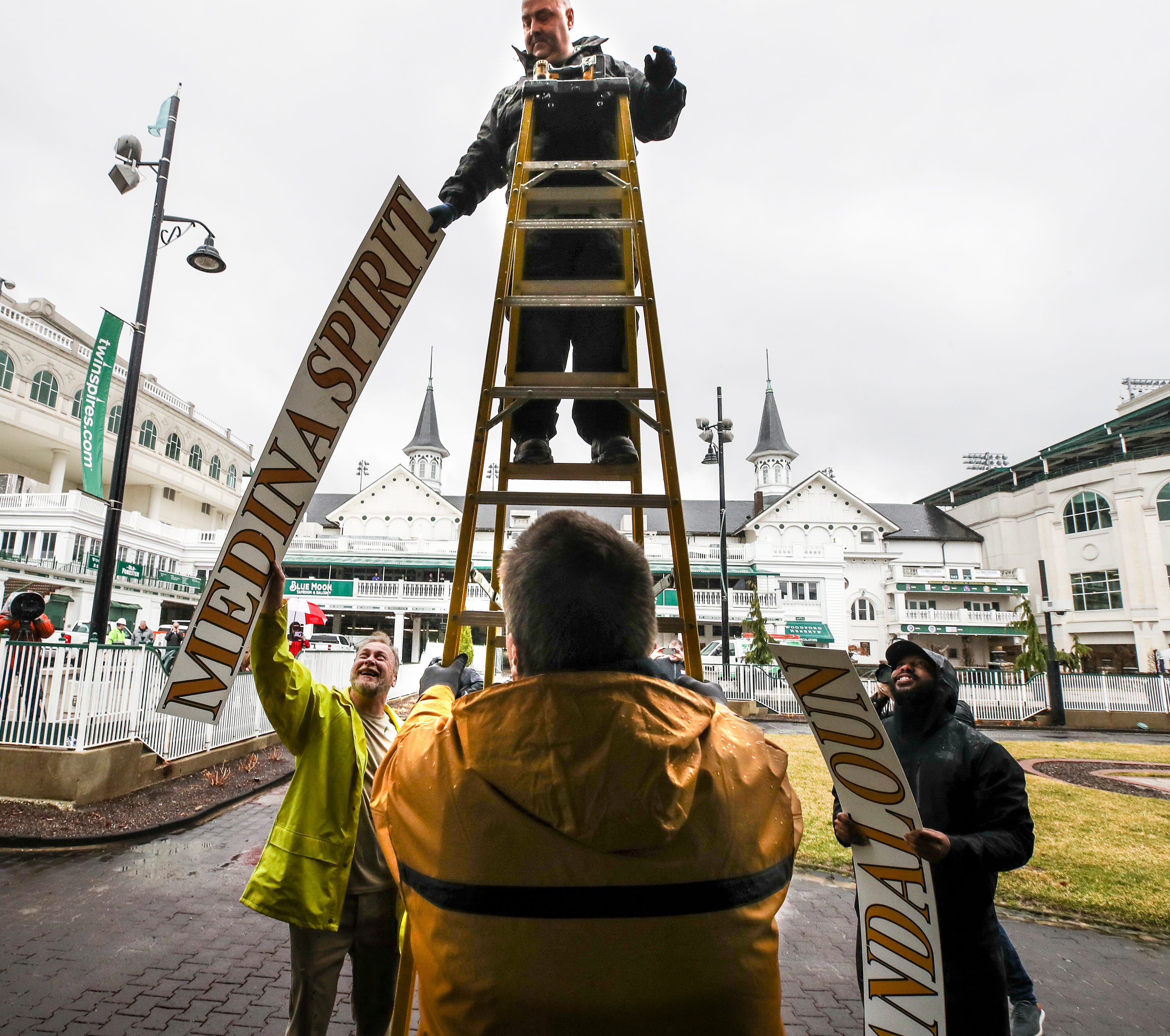 Todd Herl of the Churchill Downs sign shop removes the name of Medina Spirit in the paddock at Churchill Downs on Tuesday, February 22, 2022, in Louisville, Kentucky.  Medina Spirit, trained by Bob Baffert, was disqualified as the winner of the Kentucky Derby 2021 and Mandaloun, trained by Brad Cox, was declared the winner.