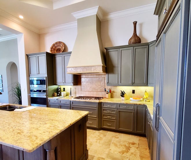 The original kitchen featured dark woods, had an ineffective island counter, tired flooring and an outdated hood over the stove.