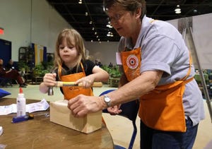 Ruby Santo, then 5, hammers away as she builds a bug house with the help of Hilda Kelley of one Depot at the 2014 Augusta Home and Garden Show.