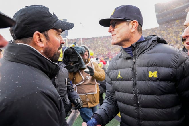 Ohio State coach Ryan Day shakes hands with Michigan coach Jim Harbaugh after Saturday's game.