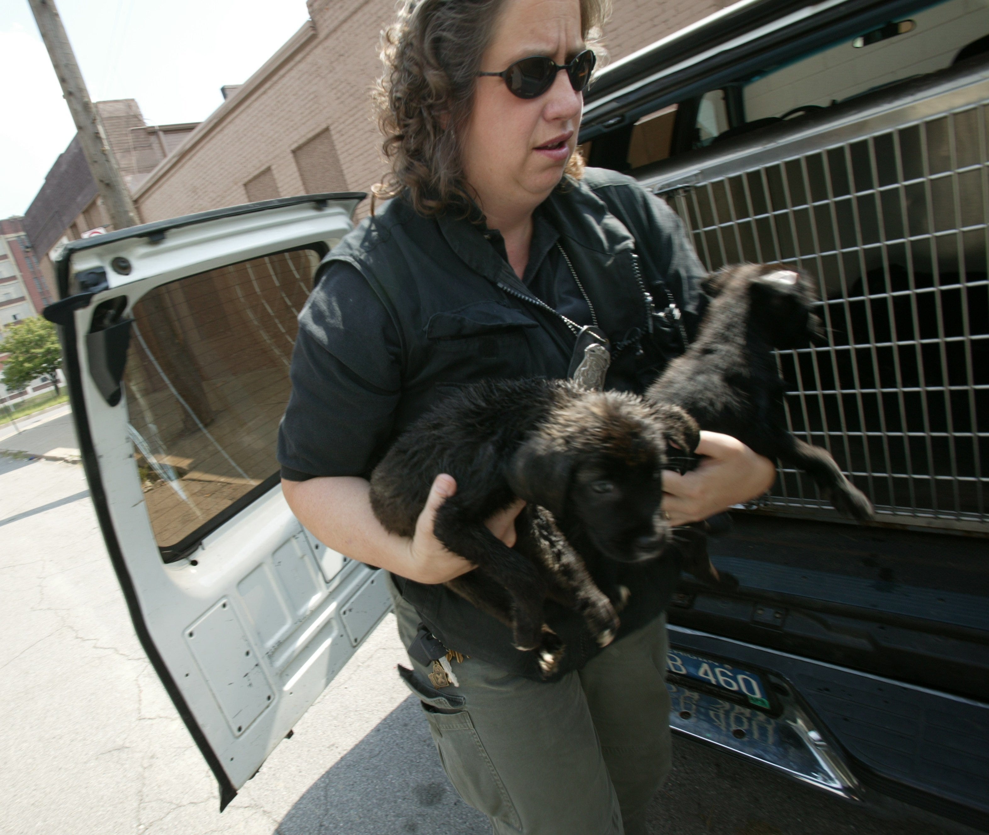 In this 2003 photo, Debby MacDonald of the Michigan Humane Society and one of the stars of "Animal Cops: Detroit" rescues puppies after investigating a complaint on the city's west side.