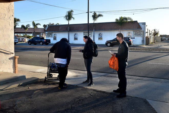 Jennifer Harkey, a project director for the County of Ventura, and Christian Lopez, of Oxnard Housing Authority, speak with Steven Anthony Galloway III on Saviers Road in Oxnard as part of the 2022 homeless count. This year's survey is planned for Jan. 24.