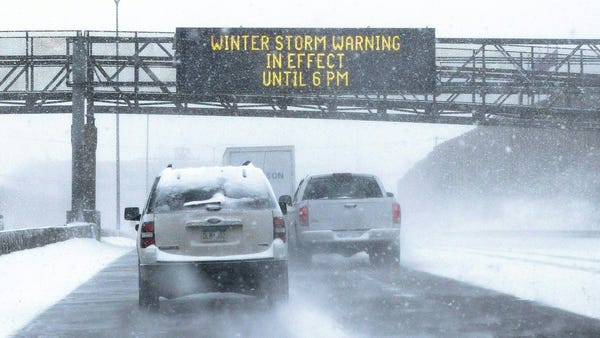 A sign warning of snow and ice conditions sits ove