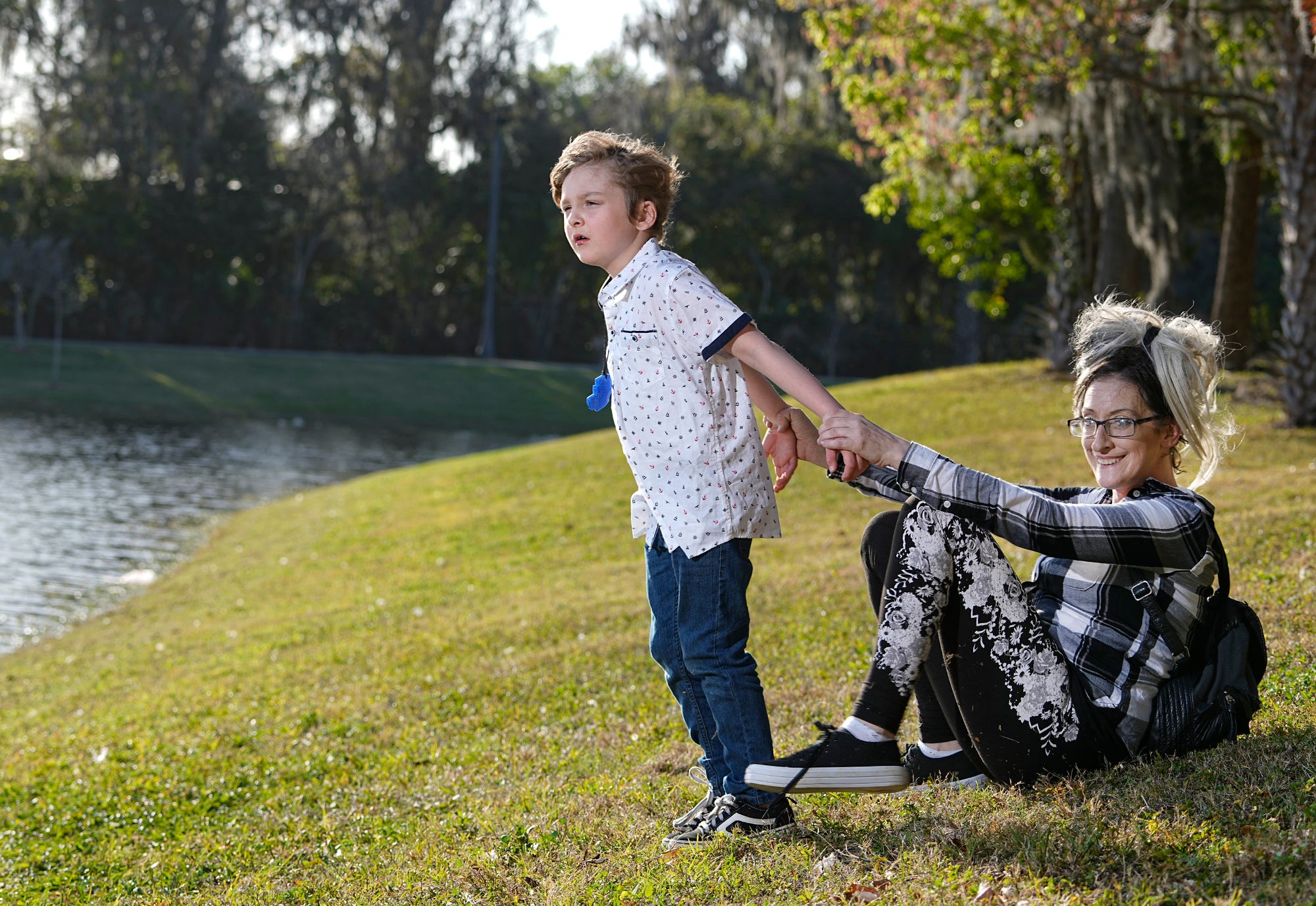 Tiffany Clark, 35, holds her son at a Daytona Beach park. Like many children with autism, Kylhar, 7, sometimes pulls away from caregivers and wears a soft toy around his neck to chew when he grows frustrated.