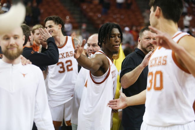 Texas guard Marcus Carr, center, celebrates with forward Brock Cunningham after Wednesday night's 75-66 victory over TCU at the Erwin Center. Carr scored 16 of his 19 points in the second half to help the Horns avoid a second consecutive home loss.