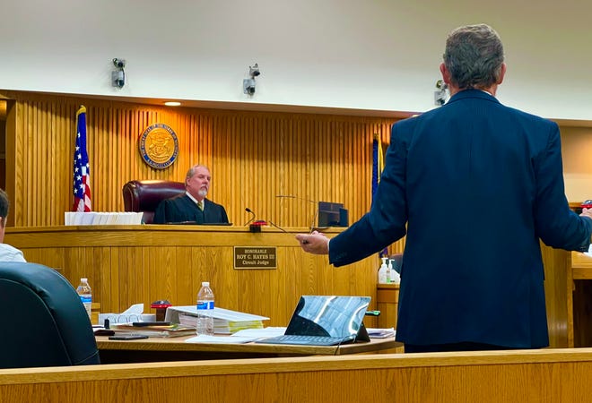 Pleading not guilty to charges of child abuse, John Paul Fiedorek's defense attorney, Michael Corcoran (right), cross-examines a prosecution witness on the stand on Feb. 22. Presiding over the trial is the Honorable Roy C. Hayes III (left), Chief Judge of the 33rd Circuit Court.