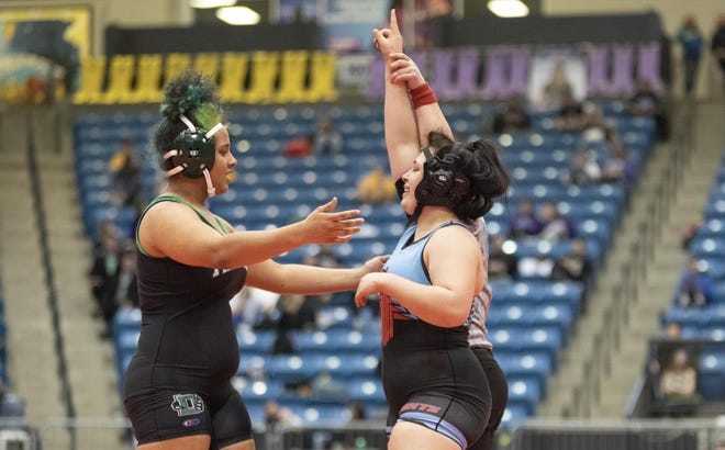 Shawnee Heights' Maranda Bell (right) has her hand raised after defeating Derby's Maya Howell in the 191 championship final on Thursday at Hartman Arena.
