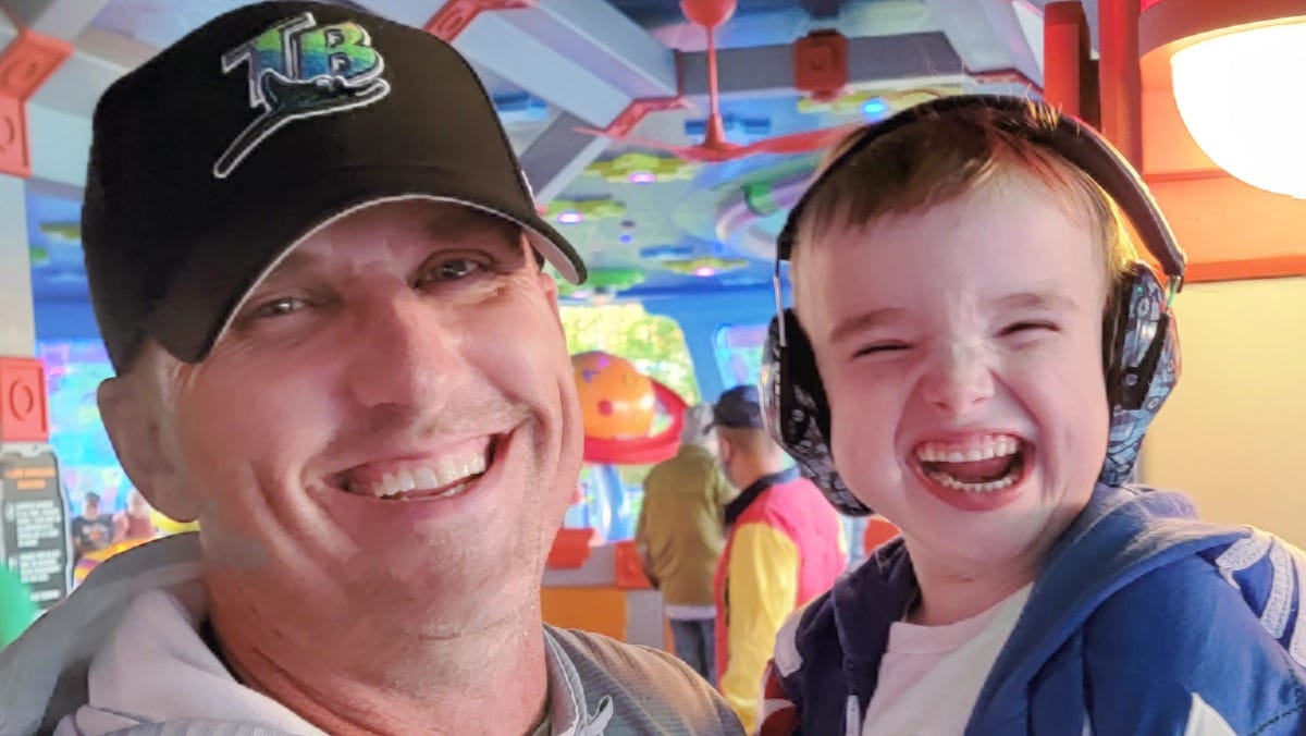 Mike Taylor of Tampa and his 7-year-old son, Raylan, who has Joubert Syndrome, are pictured at the Alien Swirling Saucers ride at Hollywood Studios' Toy Story Land.
