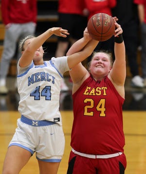 Bullitt East's Gracie Merkle (24), right, and Mercy's Leah Macy (44) battled for a rebound during the Girls 24th District Final at the Fern Creek High School in Louisville, Ky. on Feb. 23, 2022.